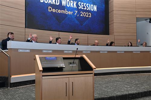 Board members voting at the dais